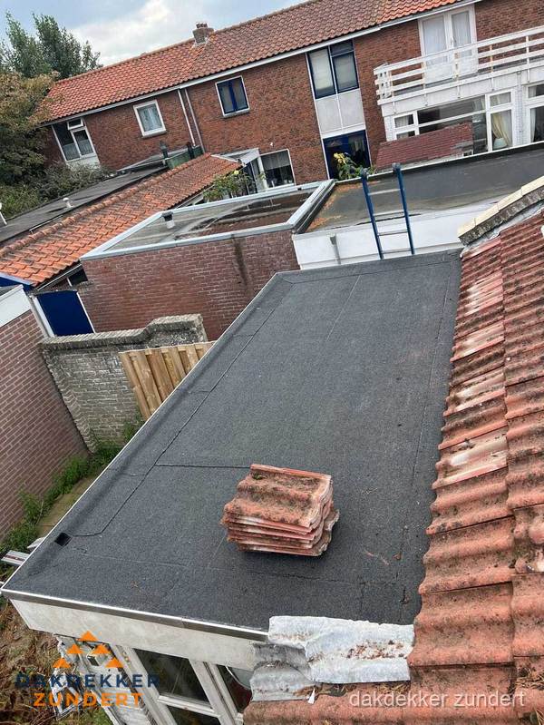 Plat dak aanbouw met bitumen naast schuin pannendak in Zundert