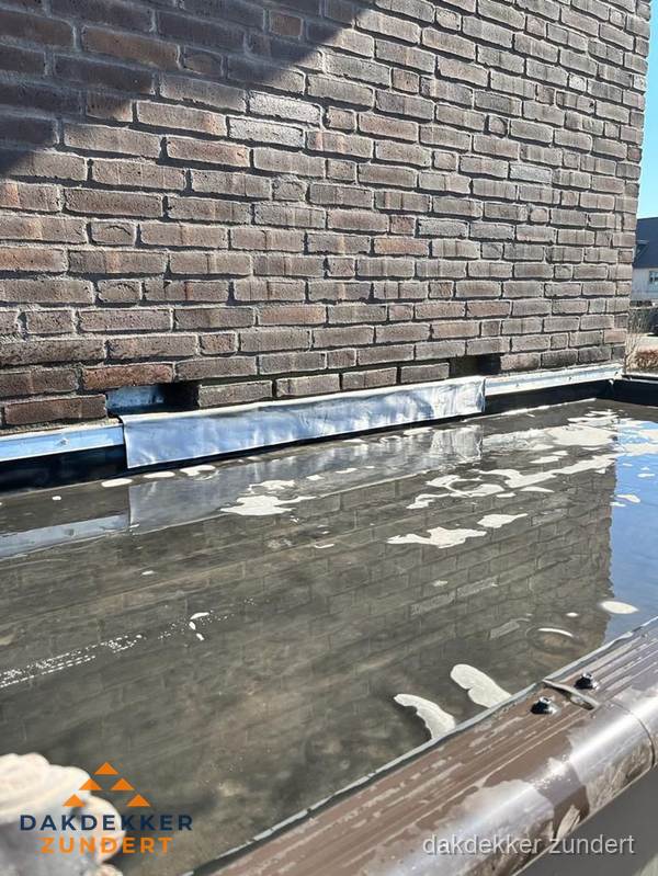 Stilstaand water op plat dak door slechte afwatering in Zundert Stilstaand water op plat dak door slechte afwatering in Zundert