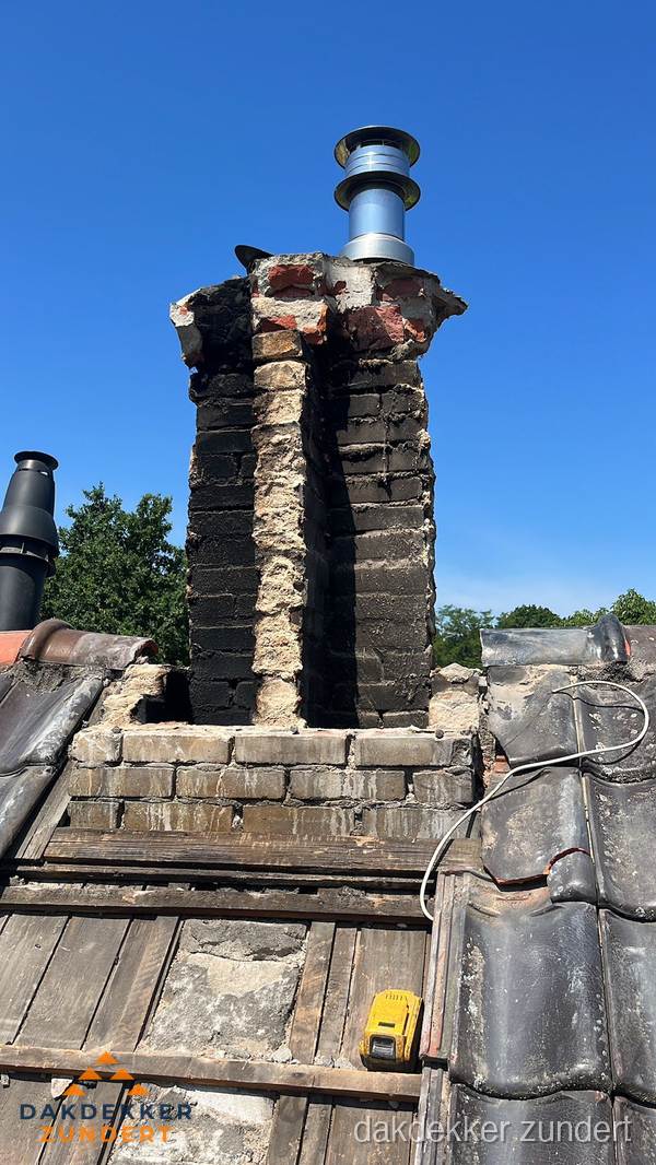 Beschadigde schoorsteen met nieuwe rookgasafvoer op oud dak in Zundert