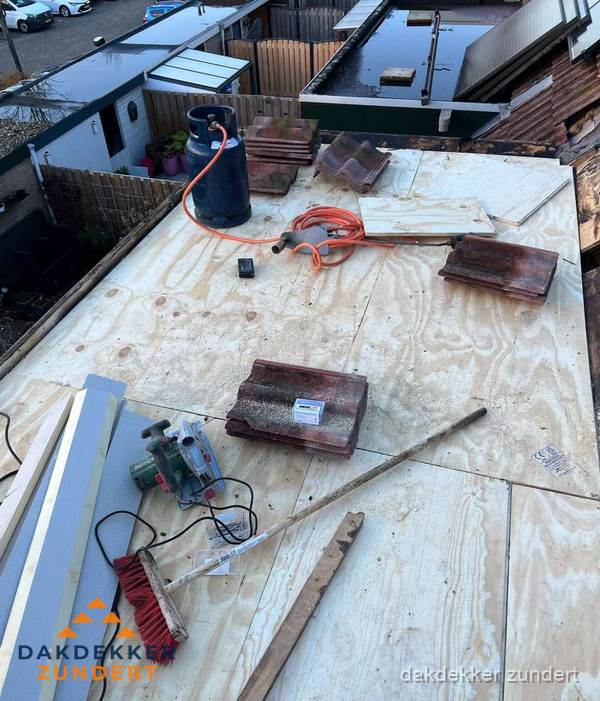 Dakreparatie werkzaamheden op plat dak met gereedschap in Zundert