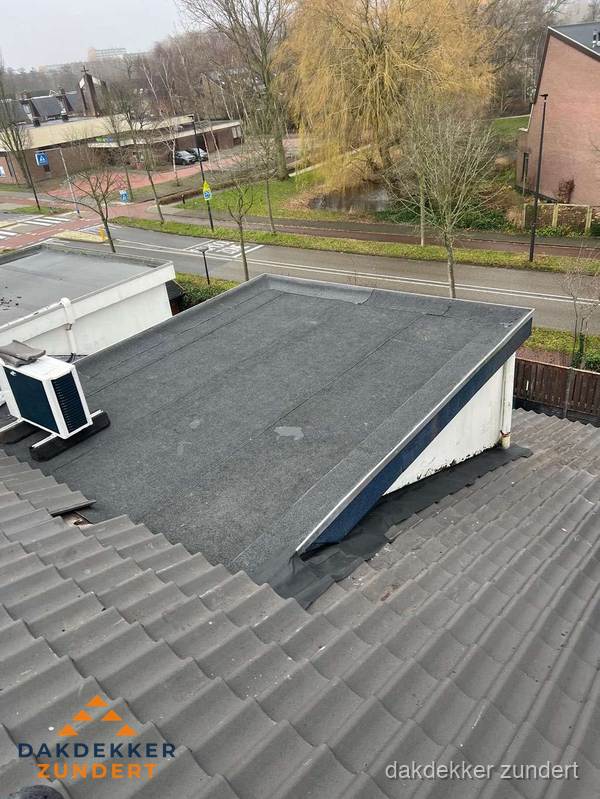 Plat dak met bitumen dakbedekking naast schuin pannendak in Zundert Plat dak met bitumen dakbedekking naast schuin pannendak in Zundert
