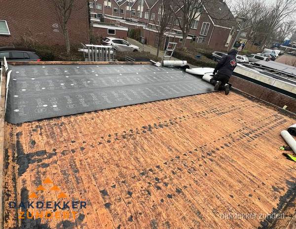 Dakdekker legt onderlaag op plat dak met houten constructie in Zundert