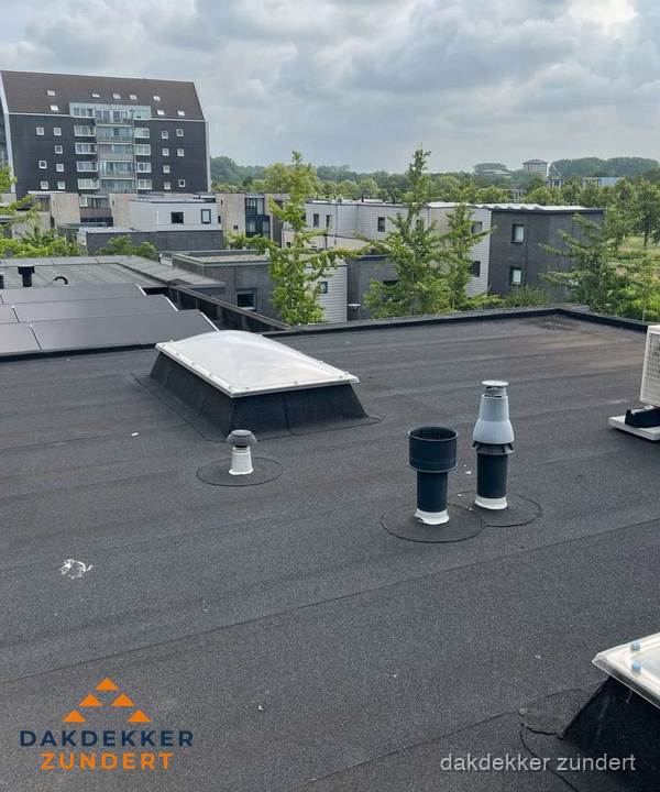 Groot plat dak met lichtkoepel en dakdoorvoeren in Zundert
