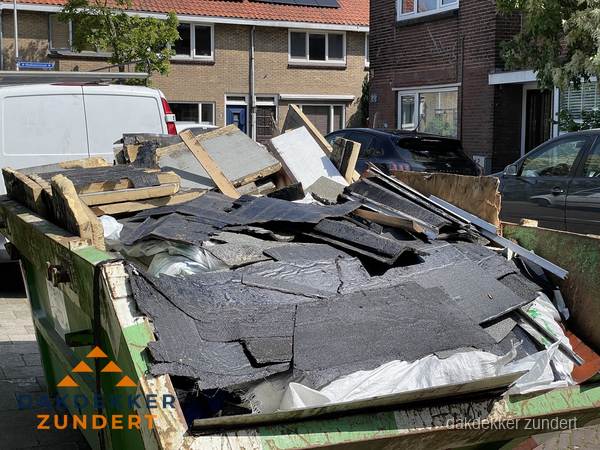 Afvalcontainer met gesloopt dakmateriaal tijdens dakkapel renovatie in Zundert Afvalcontainer met gesloopt dakmateriaal tijdens dakkapel renovatie in Zundert