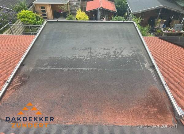Verouderd plat dak met slijtage tussen schuine daken in Zundert Verouderd plat dak met slijtage tussen schuine daken in Zundert