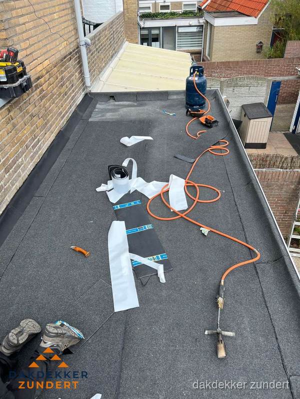 Dakdekkers bezig met bitumen dakbedekking in Zundert