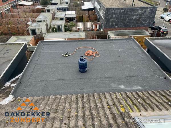 Plat dak met nieuwe bitumen dakbedekking en brandgereedschap in Zundert